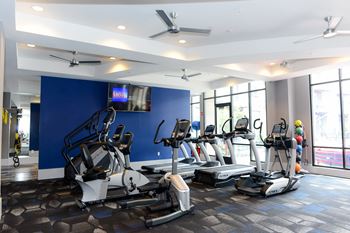 a room filled with lots of cardio equipment and a flat screen tv  at Avant & Avant II, Carmel, IN, 46032